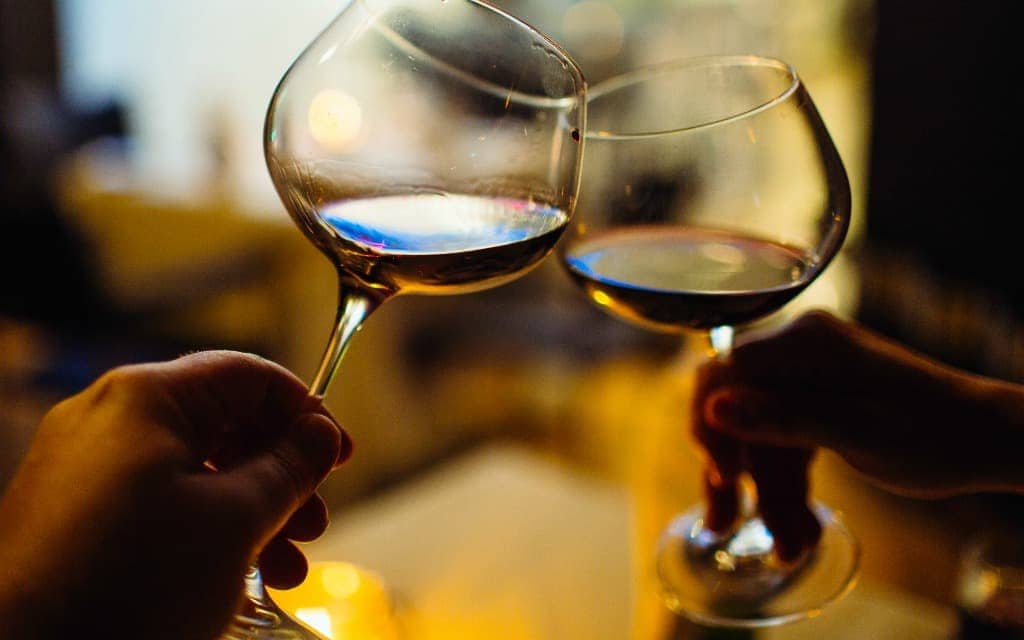 Romantic dinner wine glasses toasting