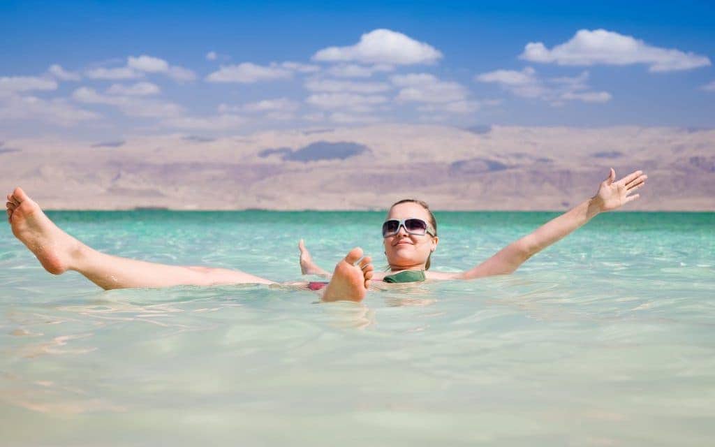Woman floating on the salty waters of the Dead Sea
