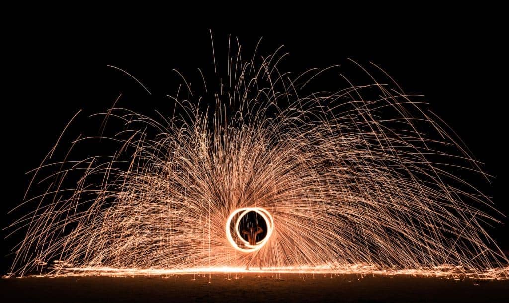 Firestarter performing amazing fire show with sparkles in the night