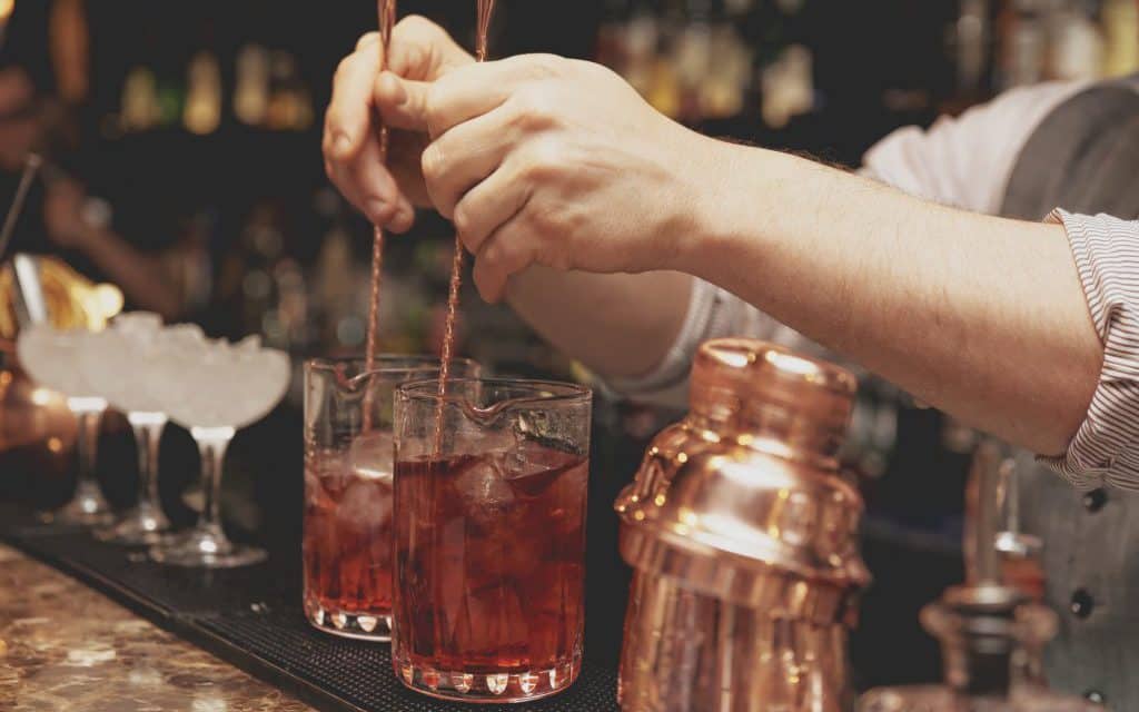 Bartender is stirring cocktails on bar counter