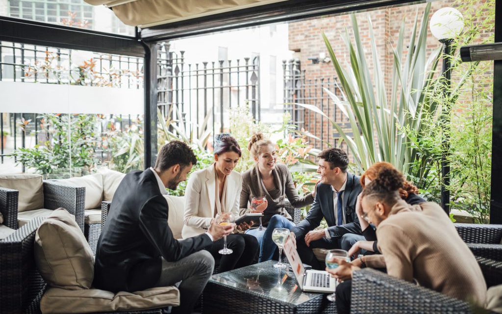 Group of business people are discussing their work in a bar courtyard after work.