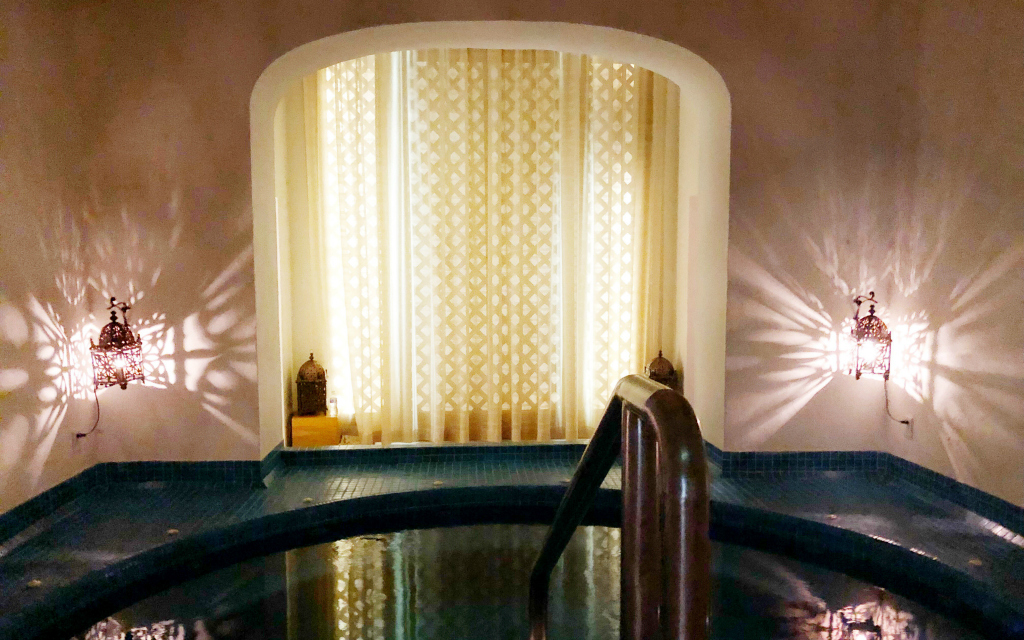 spa with white curtains in the background and lit sconces