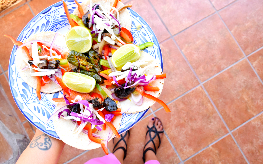 vegetarian tacos on a blue plate over red tile