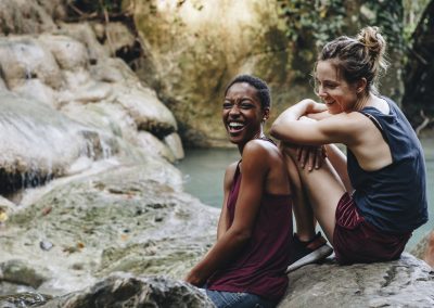 Friends hanging out by a waterfall in the jungle